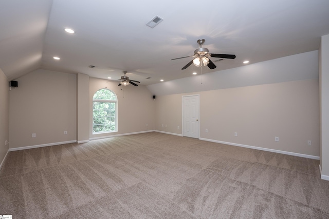 spare room with visible vents, a ceiling fan, lofted ceiling, and light colored carpet