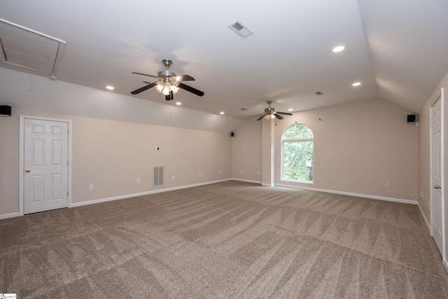 carpeted spare room featuring visible vents, lofted ceiling, and attic access