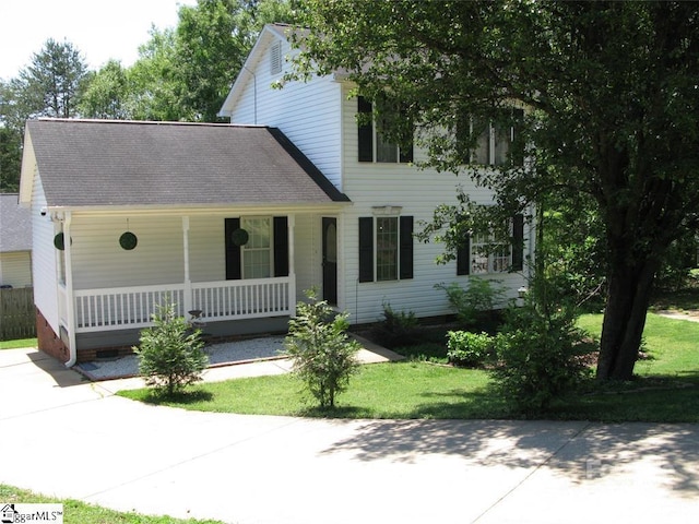 colonial inspired home featuring a shingled roof and a porch