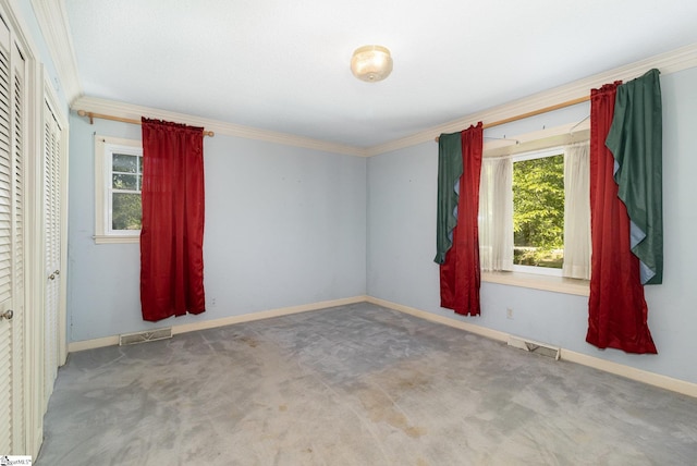 carpeted spare room featuring baseboards, visible vents, and ornamental molding