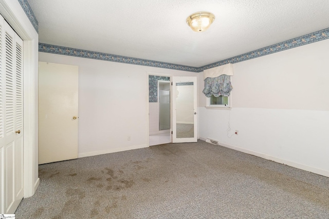 unfurnished bedroom with baseboards, visible vents, carpet, and a closet