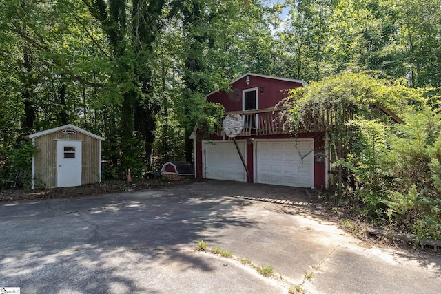 garage featuring a storage shed and driveway