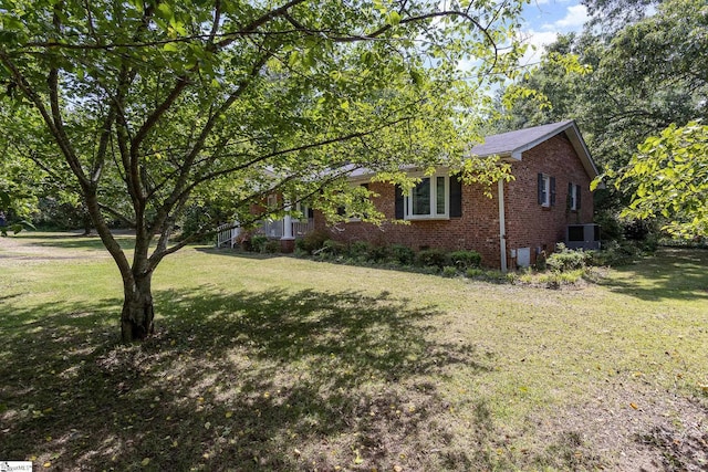 view of front of property featuring brick siding, central AC, and a front yard