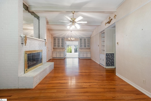 unfurnished living room with baseboards, a brick fireplace, wood finished floors, and beamed ceiling