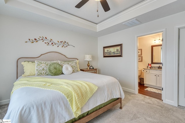bedroom featuring visible vents, crown molding, baseboards, light colored carpet, and a tray ceiling