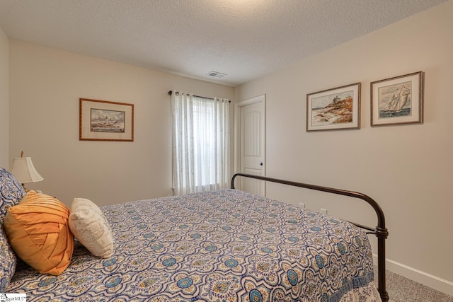 carpeted bedroom with a textured ceiling, baseboards, and visible vents
