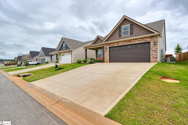 craftsman-style house with a front lawn, central AC, stone siding, and concrete driveway