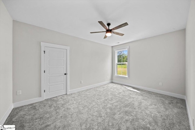 unfurnished room with carpet flooring, a ceiling fan, and baseboards