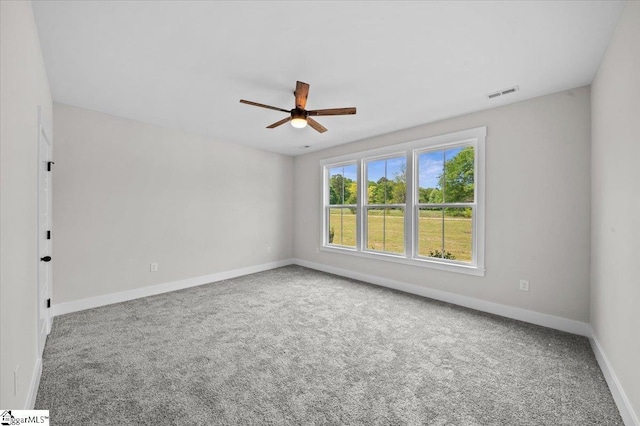 carpeted spare room with a ceiling fan, baseboards, and visible vents