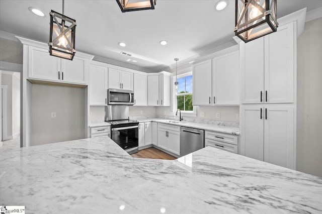 kitchen with recessed lighting, white cabinetry, light stone counters, a sink, and stainless steel appliances