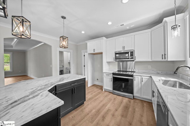 kitchen featuring appliances with stainless steel finishes, a sink, white cabinets, ornamental molding, and recessed lighting