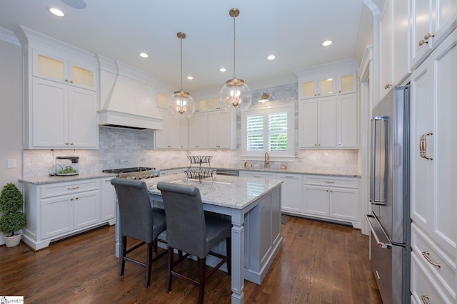 kitchen featuring white cabinetry, appliances with stainless steel finishes, and premium range hood