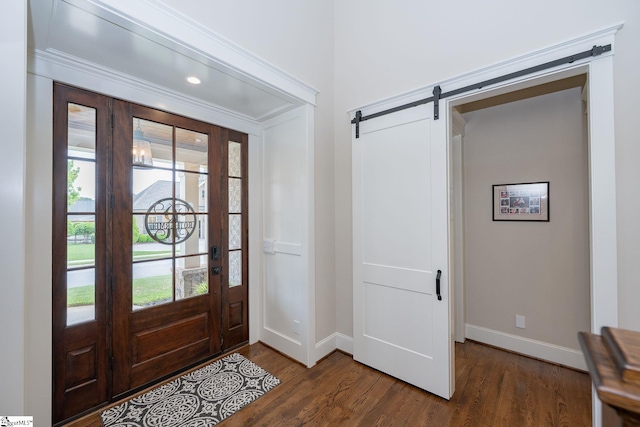 foyer featuring baseboards, dark wood-style floors, and a barn door