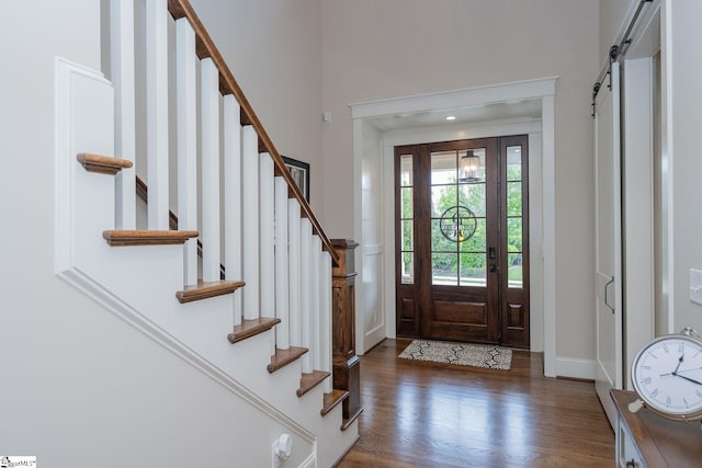 foyer with stairway, baseboards, ornamental molding, and wood finished floors