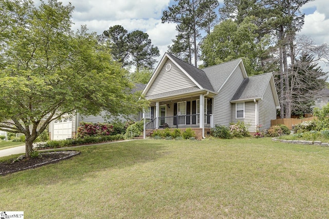 view of front of property with covered porch, a garage, fence, and a front lawn