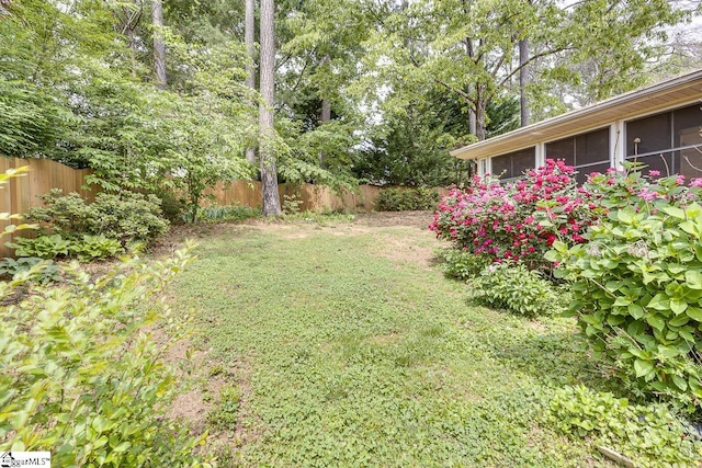 view of yard featuring a fenced backyard and a sunroom