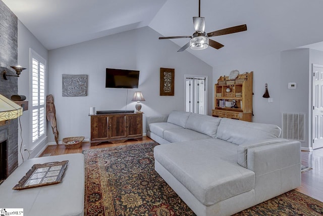 living room featuring ceiling fan, vaulted ceiling, wood finished floors, and visible vents
