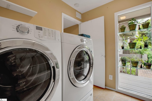 washroom featuring light tile patterned floors, separate washer and dryer, and laundry area