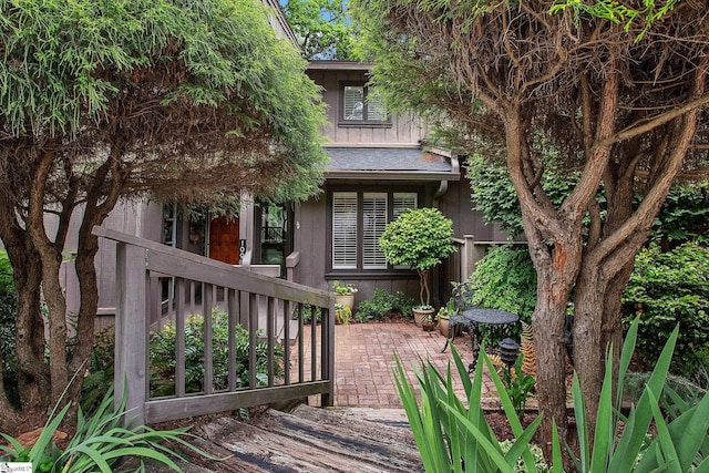 rear view of property with board and batten siding and a patio area