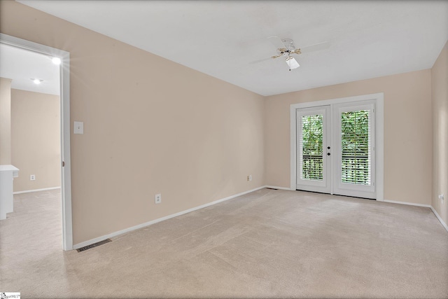 spare room with baseboards and light carpet