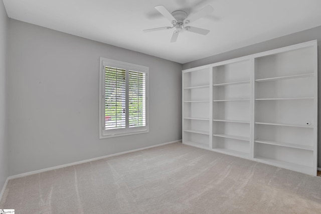 empty room featuring baseboards, carpet flooring, and ceiling fan