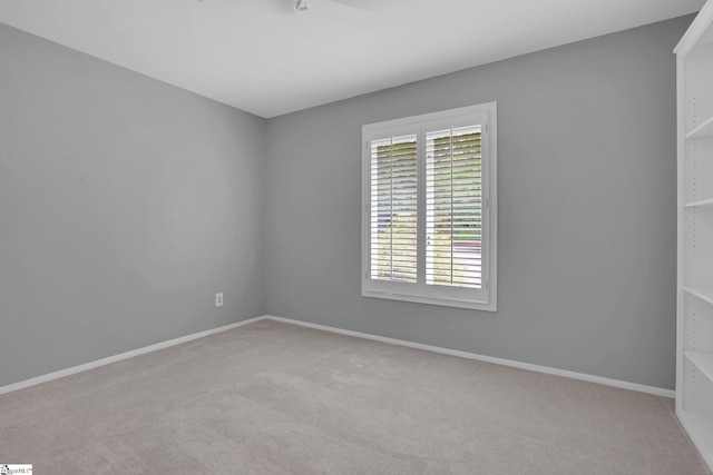 carpeted spare room featuring baseboards