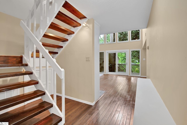 stairway with baseboards and hardwood / wood-style floors