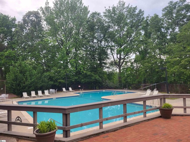 community pool featuring fence and a patio area