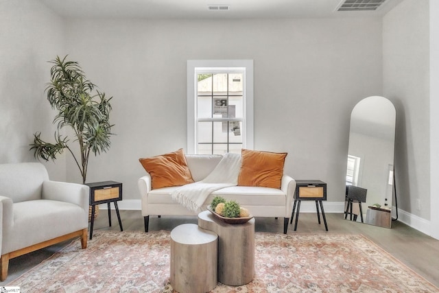 sitting room with arched walkways, visible vents, and a healthy amount of sunlight
