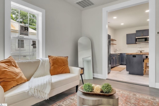 sitting room featuring visible vents, recessed lighting, light wood-style flooring, and baseboards
