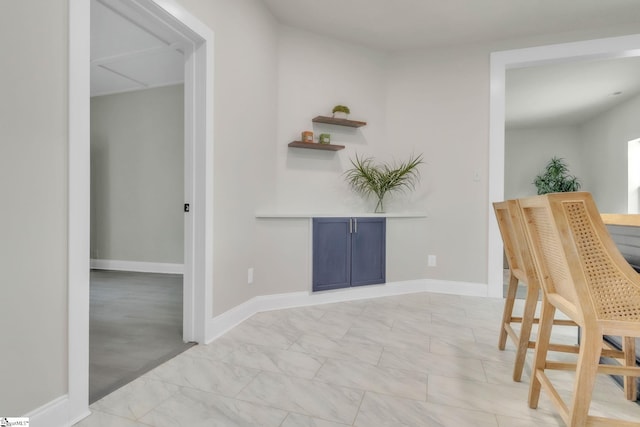 hall with baseboards and marble finish floor