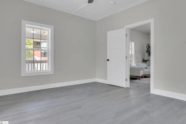 spare room with baseboards, a ceiling fan, and wood finished floors