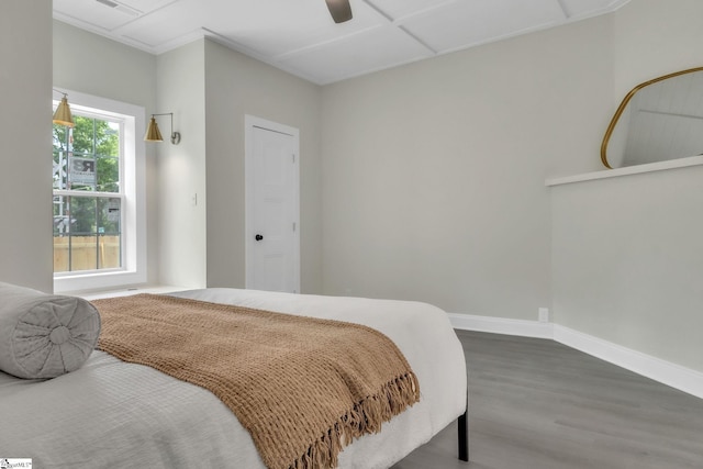 bedroom with a ceiling fan, baseboards, and wood finished floors