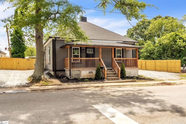 bungalow featuring fence, roof with shingles, a porch, crawl space, and a chimney