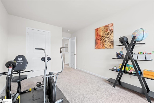 exercise room featuring baseboards and carpet