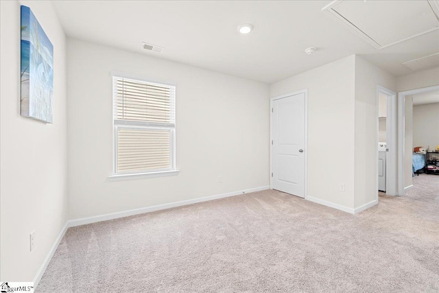 interior space featuring visible vents, light carpet, and attic access
