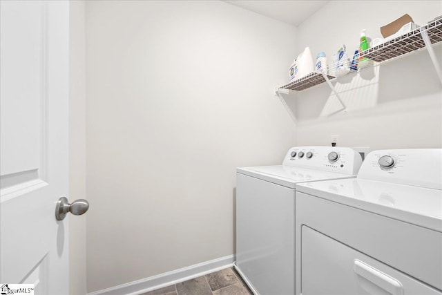 clothes washing area featuring baseboards, laundry area, and washer and clothes dryer