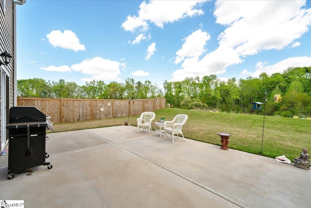 view of patio with fence and a grill