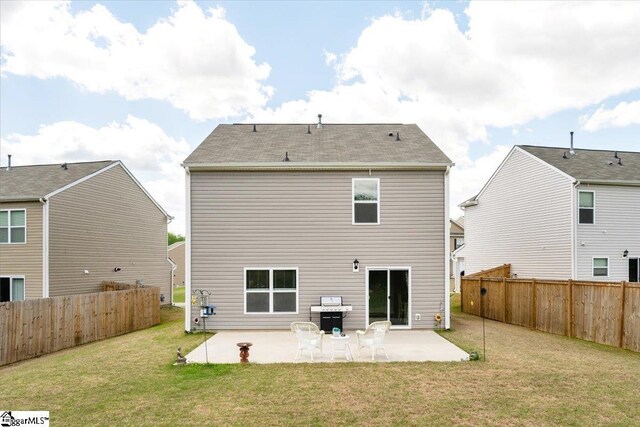 back of property with a patio, a fenced backyard, and a lawn