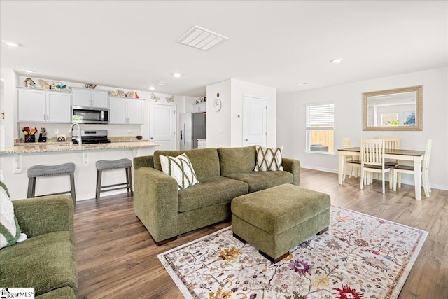 living area featuring baseboards, dark wood-style flooring, recessed lighting, and visible vents
