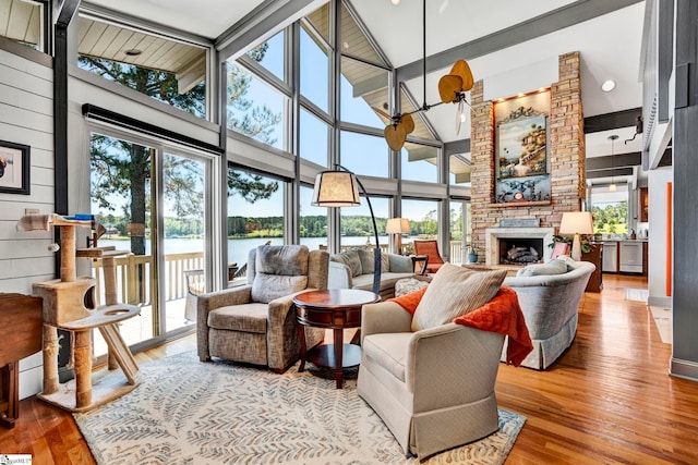 105 Seabright Cir, Cross Hill, SC 39332 - living area featuring a stone fireplace, beam ceiling, wood finished floors, high vaulted ceiling, and a water view