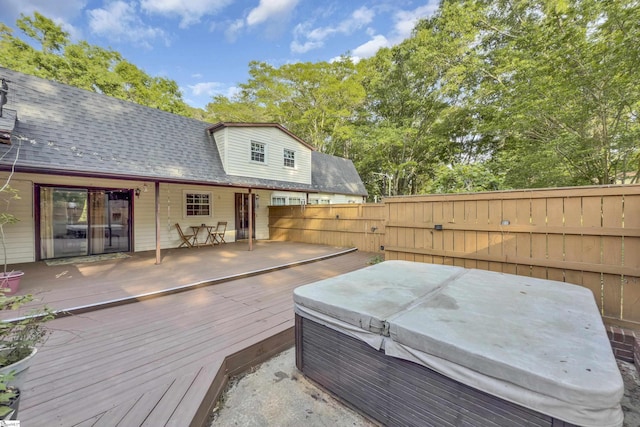 wooden terrace with a hot tub, a gate, and fence private yard