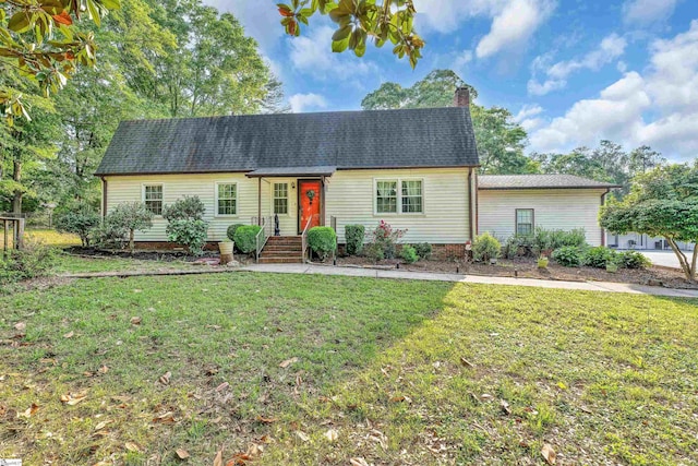 view of front of property featuring roof with shingles, a chimney, and a front lawn