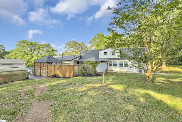 view of yard featuring an exterior structure, fence, and an outbuilding