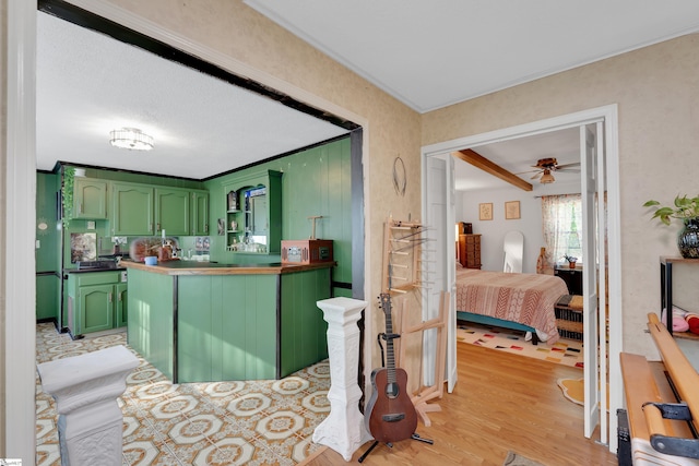 interior space featuring crown molding, vanity, wood finished floors, ceiling fan, and ensuite bath