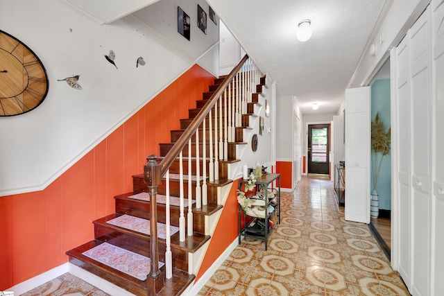 stairs with baseboards and a decorative wall