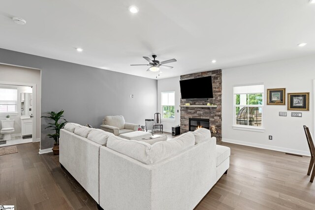 living area featuring dark wood-style flooring, baseboards, plenty of natural light, and ceiling fan