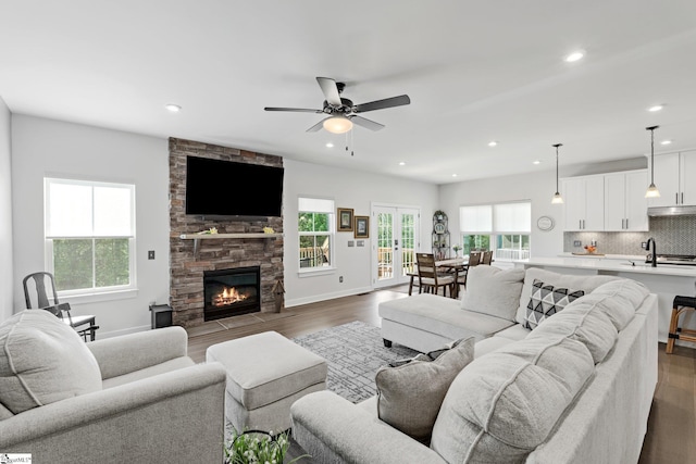 living area with a fireplace, dark wood finished floors, recessed lighting, a ceiling fan, and baseboards