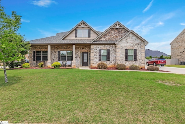 craftsman-style home featuring a porch, brick siding, and a front yard
