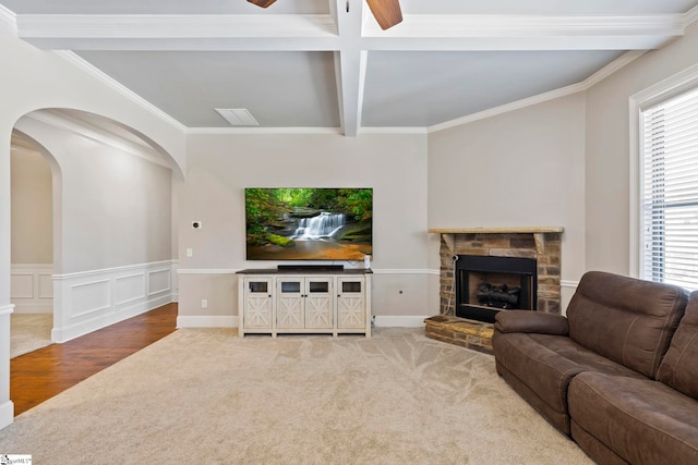 living room with carpet floors, a ceiling fan, beamed ceiling, and a wealth of natural light